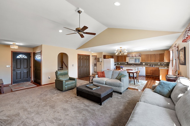 living area with recessed lighting, baseboards, high vaulted ceiling, and ceiling fan with notable chandelier