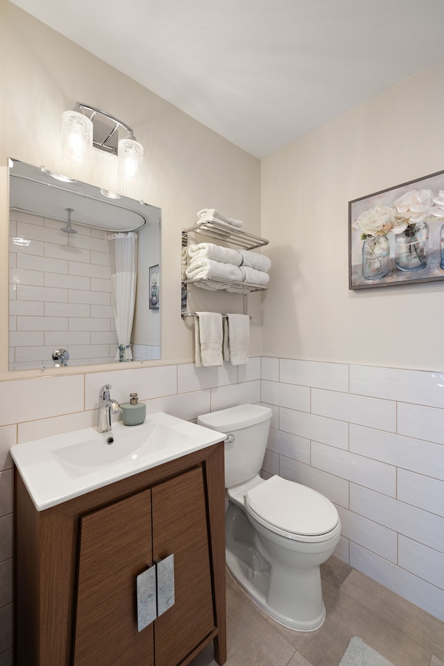 bathroom featuring vanity, tile walls, a wainscoted wall, toilet, and a shower with shower curtain
