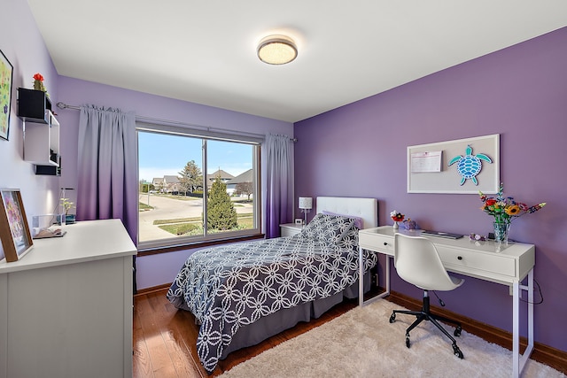 bedroom featuring baseboards and wood finished floors