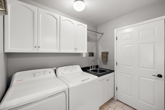 laundry area featuring cabinet space, washer and clothes dryer, light tile patterned flooring, and a sink