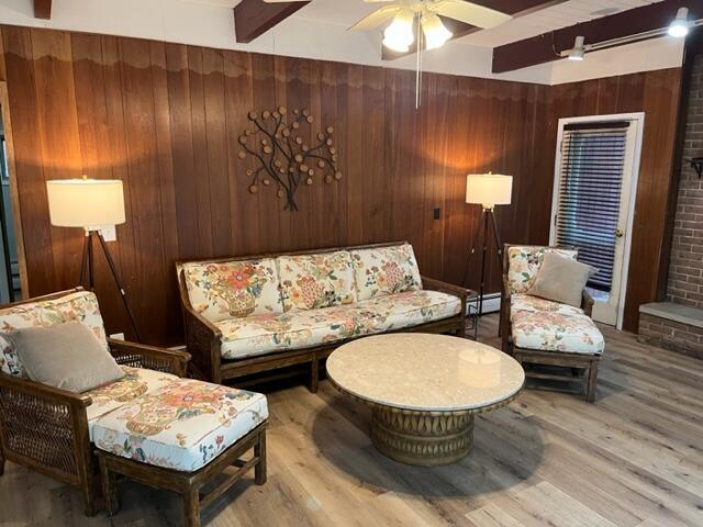 608 Terrace Dr, Houghton Lake, MI 48629 - living room with wood walls, wood finished floors, beam ceiling, and ceiling fan