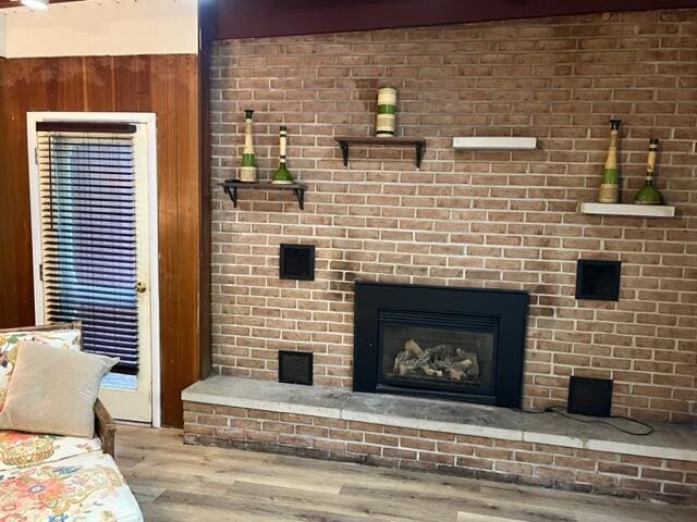 608 Terrace Dr, Houghton Lake, MI 48629 - interior details featuring wood walls, wood finished floors, and a fireplace