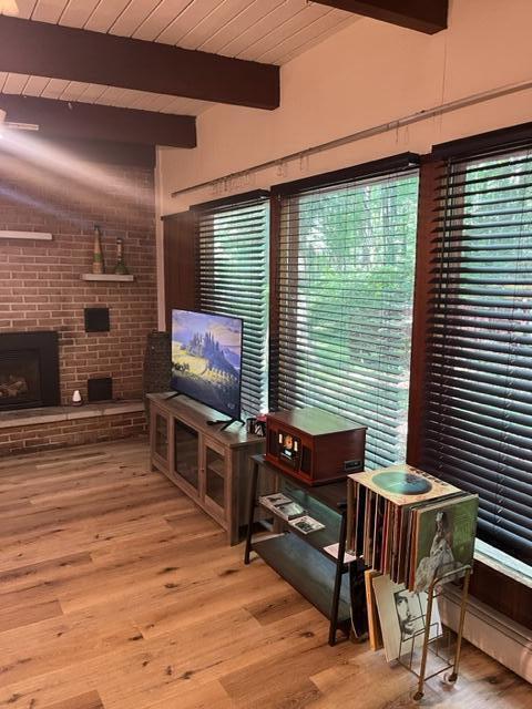 608 Terrace Dr, Houghton Lake, MI 48629 - living area featuring light wood finished floors, vaulted ceiling with beams, wooden ceiling, and a fireplace