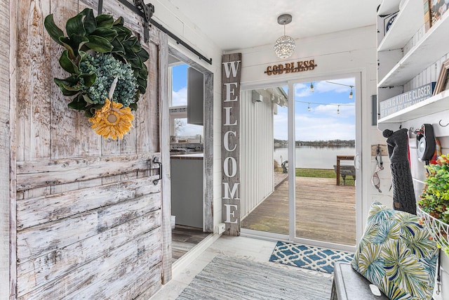 17570 Apache Trl, Howard City, MI 49329 - doorway featuring plenty of natural light, wood finished floors, a water view, and a barn door