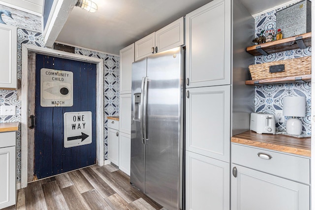 17570 Apache Trl, Howard City, MI 49329 - kitchen with white cabinetry, wallpapered walls, stainless steel refrigerator with ice dispenser, wood counters, and dark wood-type flooring