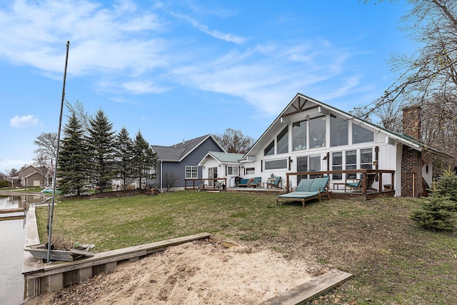 17570 Apache Trl, Howard City, MI 49329 - back of property featuring a yard, a sunroom, a chimney, and a deck