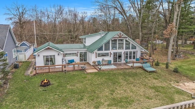 17570 Apache Trl, Howard City, MI 49329 - rear view of property featuring a fire pit, a yard, a deck, and central AC