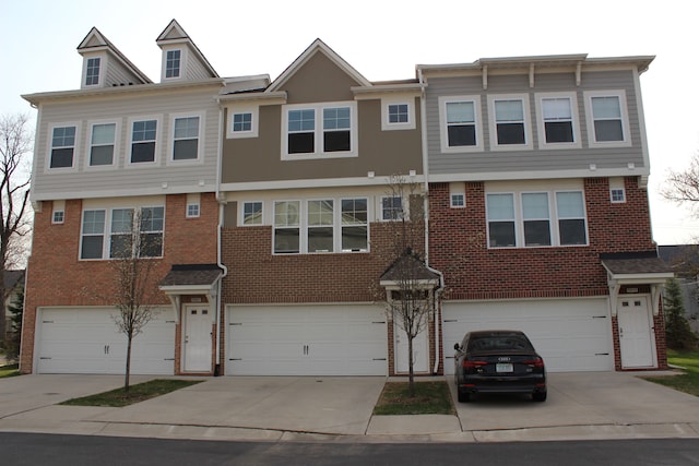 view of front of house with brick siding, driveway, and a garage