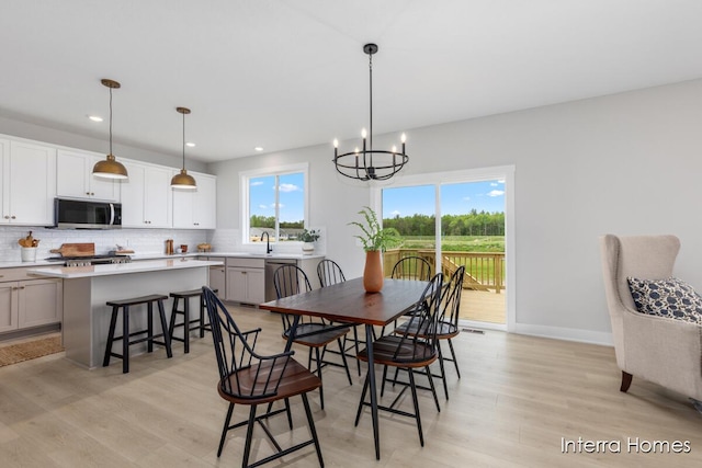 15748 Norwalk Rd, Grand Haven, MI 49417 - dining room featuring light wood-style flooring, a chandelier, recessed lighting, and baseboards