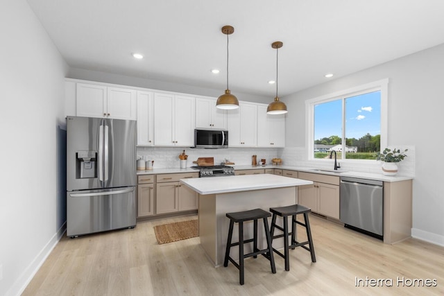 15748 Norwalk Rd, Grand Haven, MI 49417 - kitchen featuring stainless steel appliances, a sink, light wood finished floors, decorative backsplash, and light countertops