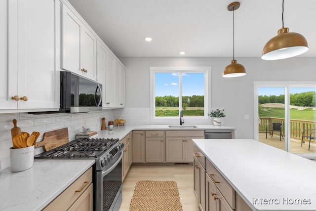 15748 Norwalk Rd, Grand Haven, MI 49417 - kitchen featuring stainless steel appliances, a sink, recessed lighting, backsplash, and light stone countertops