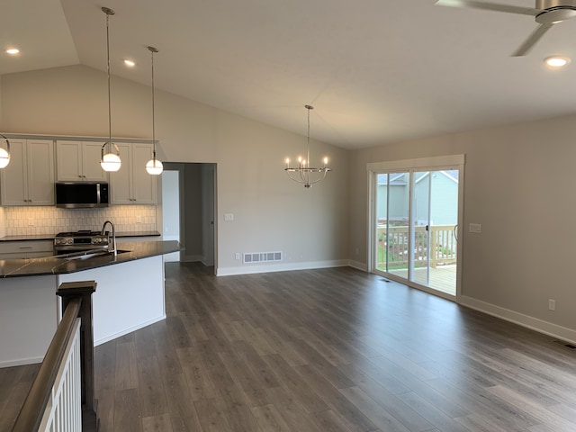 12580 Riverton Rd, Grand Haven, MI 49417 - kitchen with appliances with stainless steel finishes, dark countertops, decorative backsplash, a chandelier, and ceiling fan