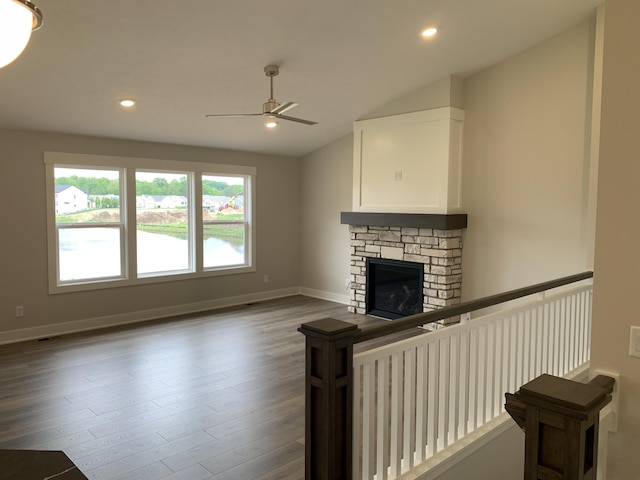 12580 Riverton Rd, Grand Haven, MI 49417 - unfurnished living room featuring a ceiling fan, wood finished floors, lofted ceiling, recessed lighting, and a stone fireplace