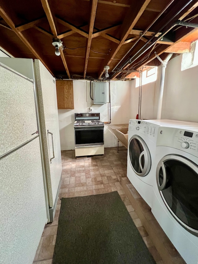 laundry room with washing machine and dryer, electric panel, and laundry area