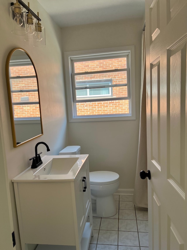 half bath with toilet, vanity, and tile patterned floors