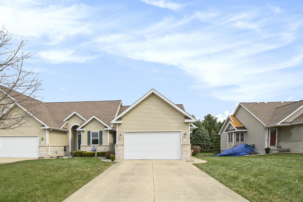 1308 Carpathian Way, Clio, MI 48420 - ranch-style home featuring brick siding, an attached garage, driveway, and a front lawn