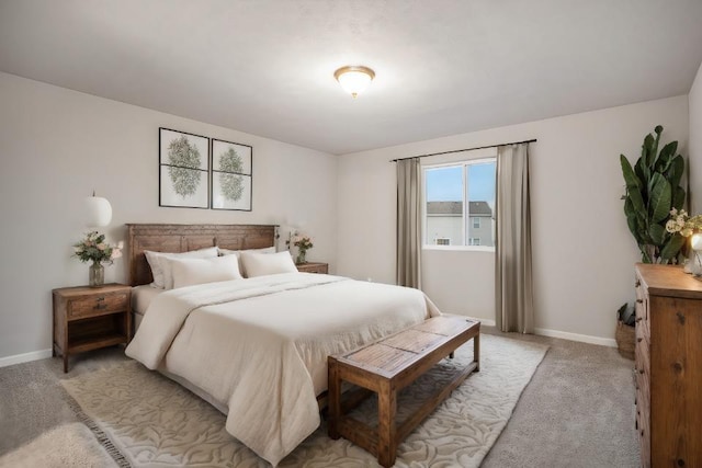 bedroom with light colored carpet and baseboards