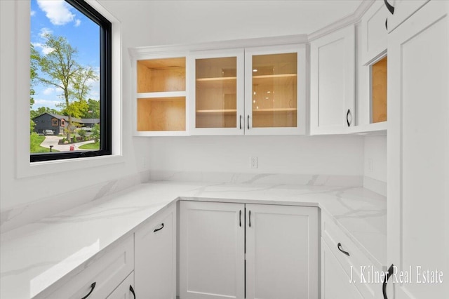 9465 Wabasis Pointe Dr NE, Greenville, MI 48838 - kitchen featuring white cabinets, glass insert cabinets, and light stone countertops