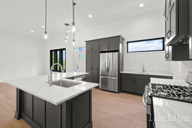 9465 Wabasis Pointe Dr NE, Greenville, MI 48838 - kitchen with stainless steel appliances, a sink, a center island with sink, light wood-style flooring, and recessed lighting