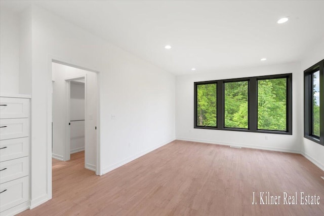 9465 Wabasis Pointe Dr NE, Greenville, MI 48838 - empty room with healthy amount of natural light, light wood finished floors, recessed lighting, and baseboards