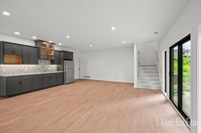 9465 Wabasis Pointe Dr NE, Greenville, MI 48838 - kitchen with freestanding refrigerator, a sink, backsplash, light countertops, and light wood-type flooring