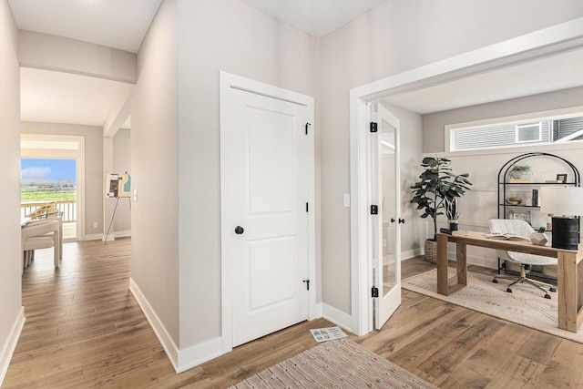 10495 Poppy Ln, Allendale, MI 49401 - hallway with light wood-type flooring, a desk, and baseboards