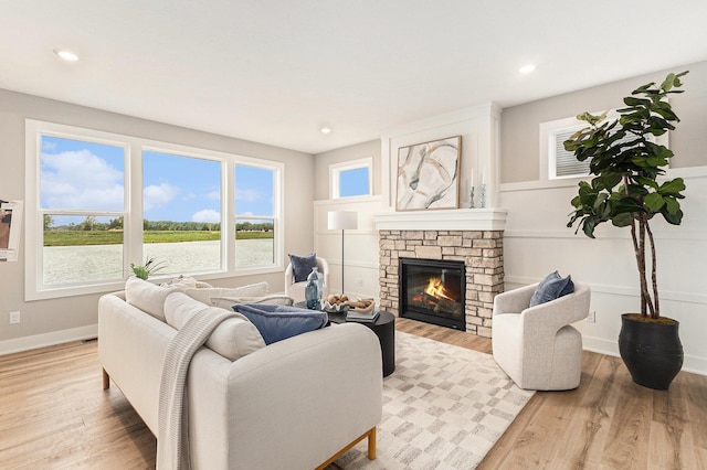 10495 Poppy Ln, Allendale, MI 49401 - living room featuring light wood-type flooring, a stone fireplace, recessed lighting, and baseboards