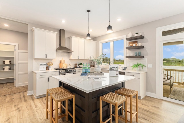 10495 Poppy Ln, Allendale, MI 49401 - kitchen featuring wall chimney range hood, a kitchen bar, tasteful backsplash, a kitchen island, and recessed lighting
