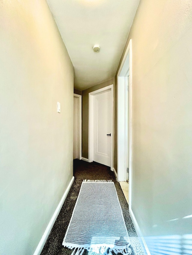 10342 Britain St, Detroit, MI 48224 - hallway featuring dark carpet and baseboards