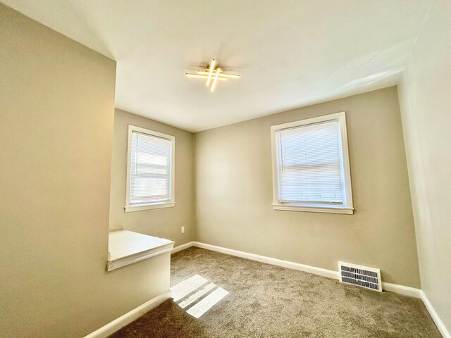 10342 Britain St, Detroit, MI 48224 - spare room featuring visible vents, carpet floors, and baseboards