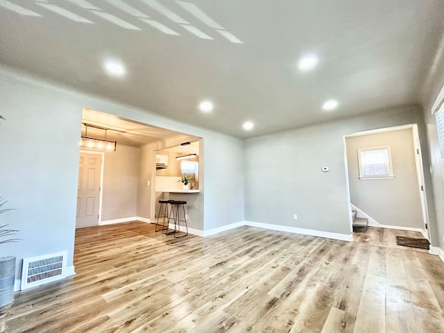 10342 Britain St, Detroit, MI 48224 - unfurnished living room featuring recessed lighting, wood finished floors, stairway, baseboards, and visible vents