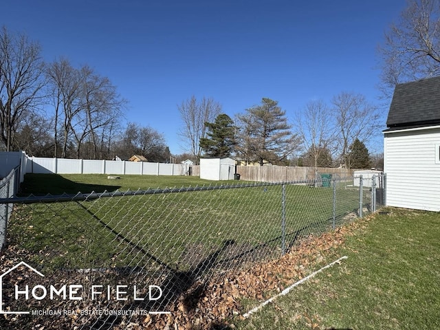 view of yard with a fenced backyard, an outbuilding, and a storage shed