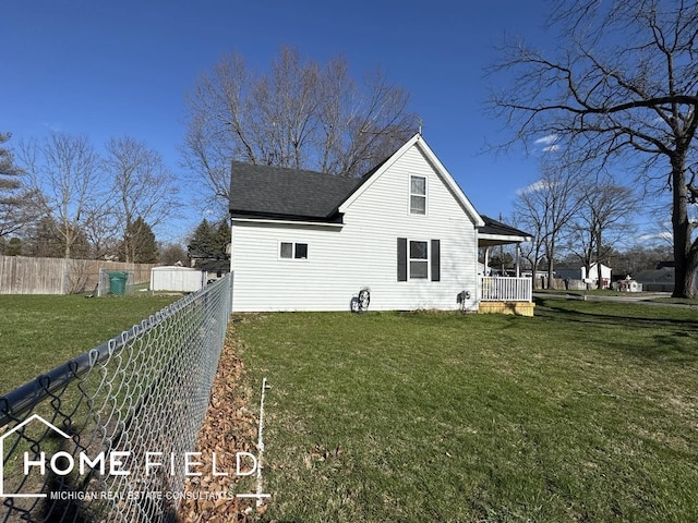 view of side of property with a yard, a porch, a shingled roof, and fence
