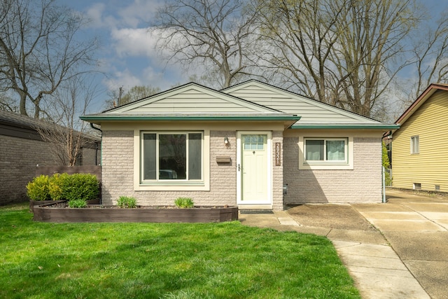 view of front of home with brick siding and a front lawn