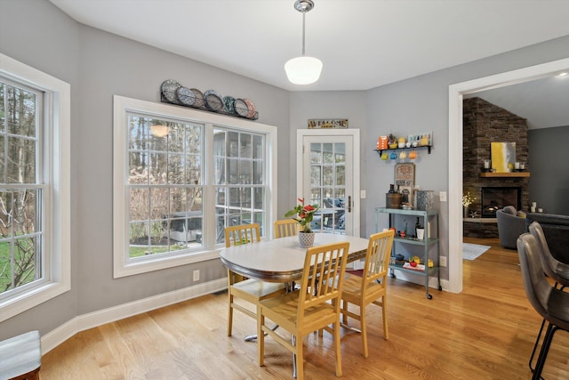 17867 K-Line Way, Marshall, MI 49068 - dining space featuring a fireplace, light wood-style flooring, and baseboards