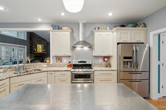 17867 K-Line Way, Marshall, MI 49068 - kitchen featuring a sink, light wood-type flooring, wall chimney exhaust hood, appliances with stainless steel finishes, and light stone countertops