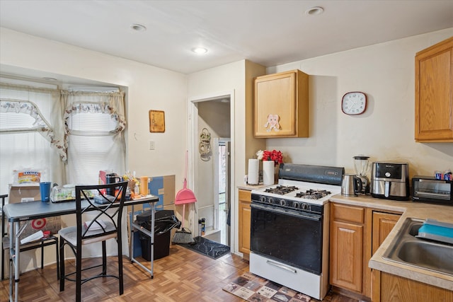 11908 Roxbury St, Detroit, MI 48224 - kitchen featuring white range with gas stovetop, light countertops, and a sink