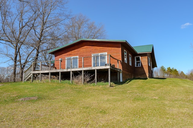 back of house with a lawn, metal roof, and a deck