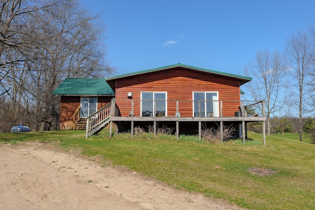 back of house featuring a wooden deck and a lawn