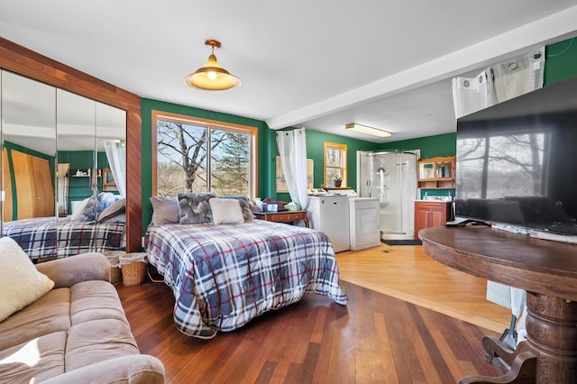 bedroom featuring independent washer and dryer and wood finished floors