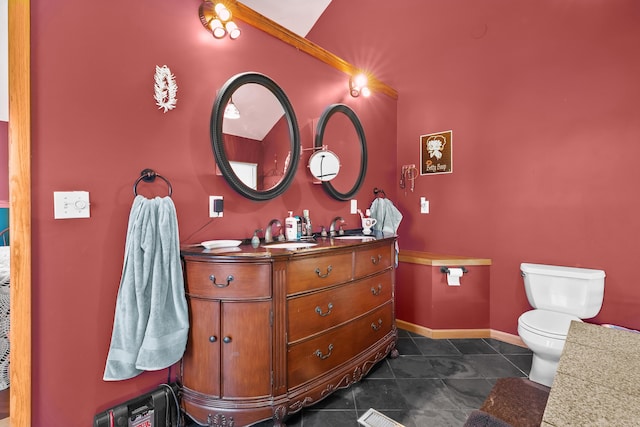 bathroom featuring baseboards, vanity, tile patterned flooring, and toilet