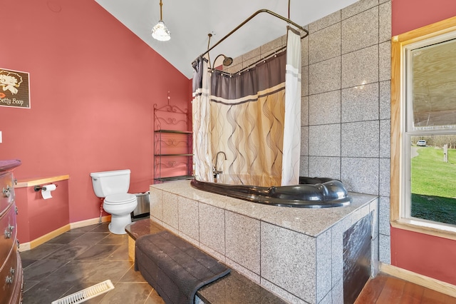 bathroom featuring lofted ceiling, baseboards, curtained shower, and toilet
