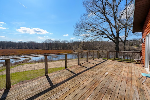 deck featuring a forest view, a water view, and a yard