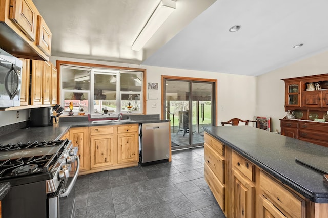 kitchen with recessed lighting, stainless steel appliances, dark countertops, vaulted ceiling, and a sink