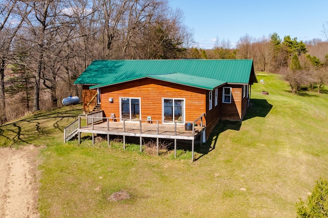 rear view of house with a lawn, stairway, a deck, and metal roof