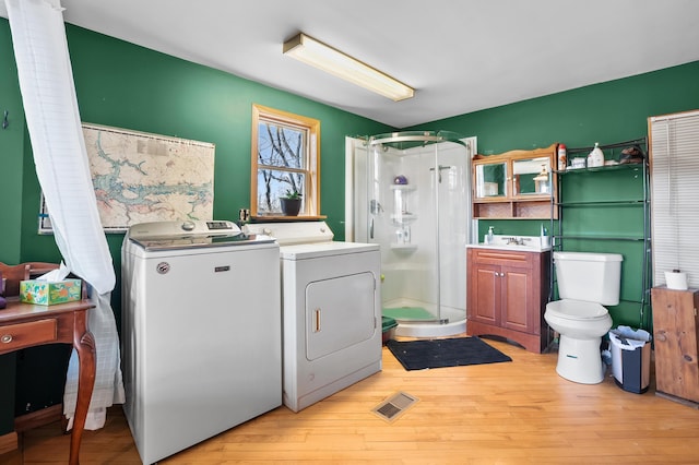 washroom featuring laundry area, visible vents, a sink, independent washer and dryer, and light wood-type flooring
