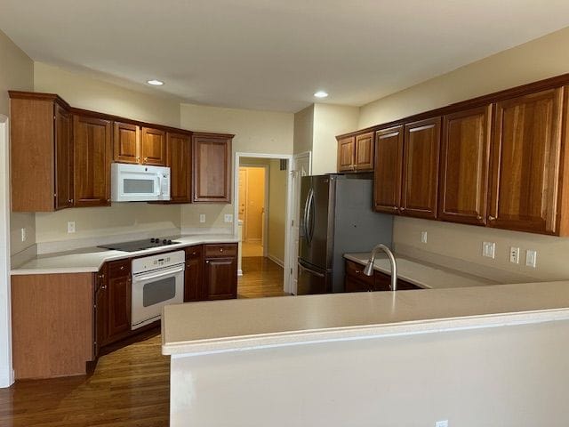 5081 Belmonte Dr, Rochester, MI 48306 - kitchen with recessed lighting, dark wood-style floors, light countertops, white appliances, and a peninsula