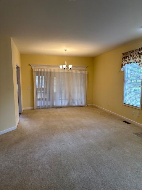 5081 Belmonte Dr, Rochester, MI 48306 - unfurnished room featuring carpet floors, baseboards, a notable chandelier, and visible vents