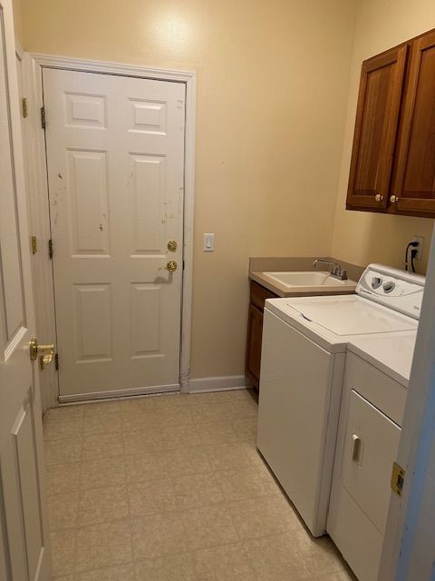 5081 Belmonte Dr, Rochester, MI 48306 - laundry room with a sink, washing machine and dryer, baseboards, cabinet space, and light floors