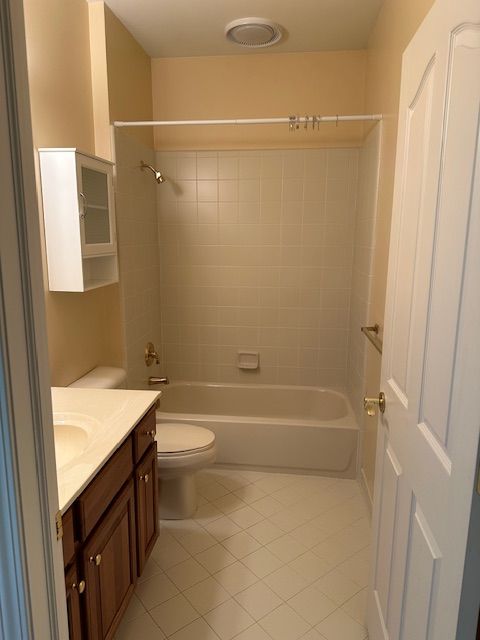 5081 Belmonte Dr, Rochester, MI 48306 - full bathroom with toilet, vanity, tile patterned floors, and shower / tub combination